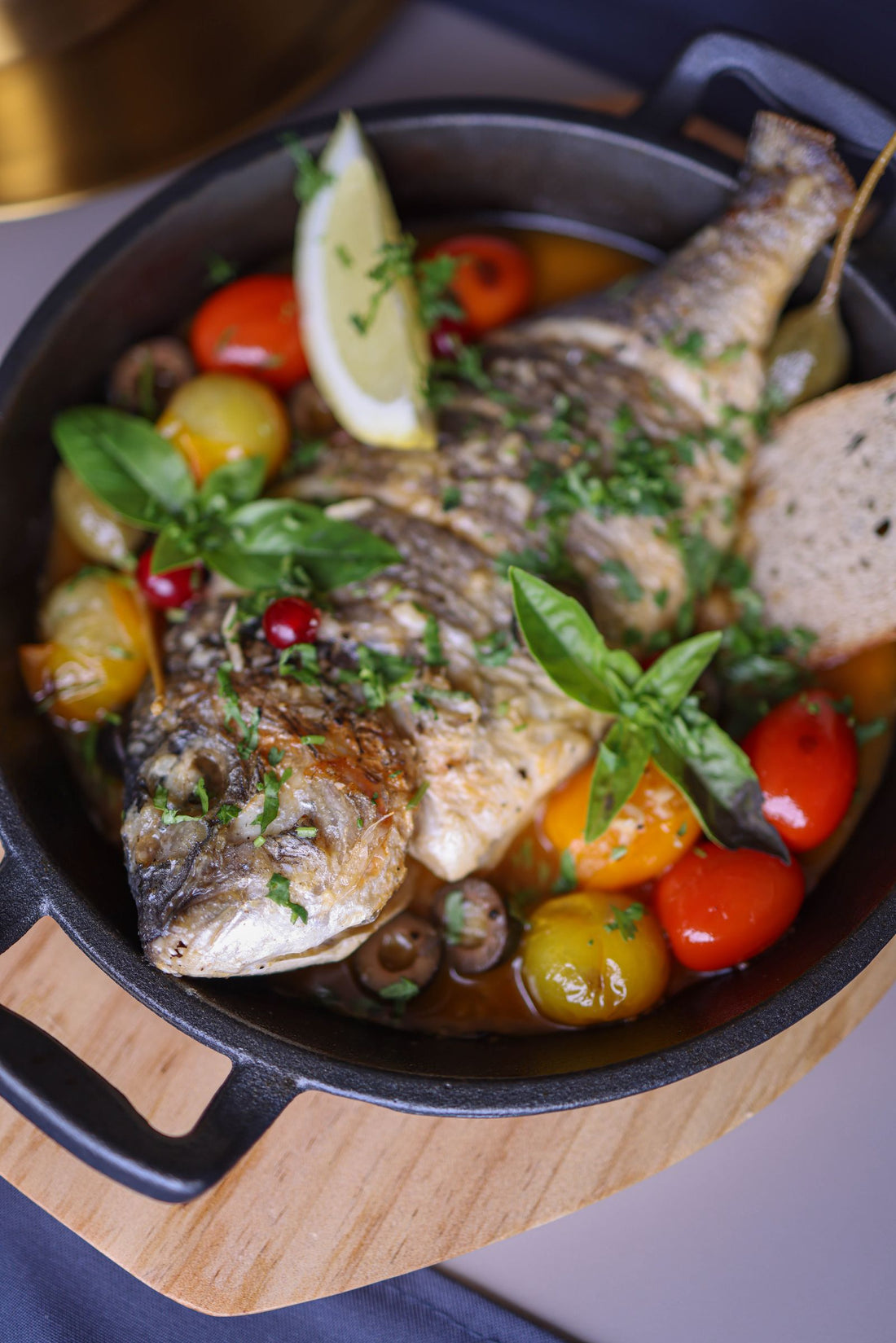 Baked fish with cherry tomatoes, olives and herbs – photo by Valeria Boltneva, Pexels
