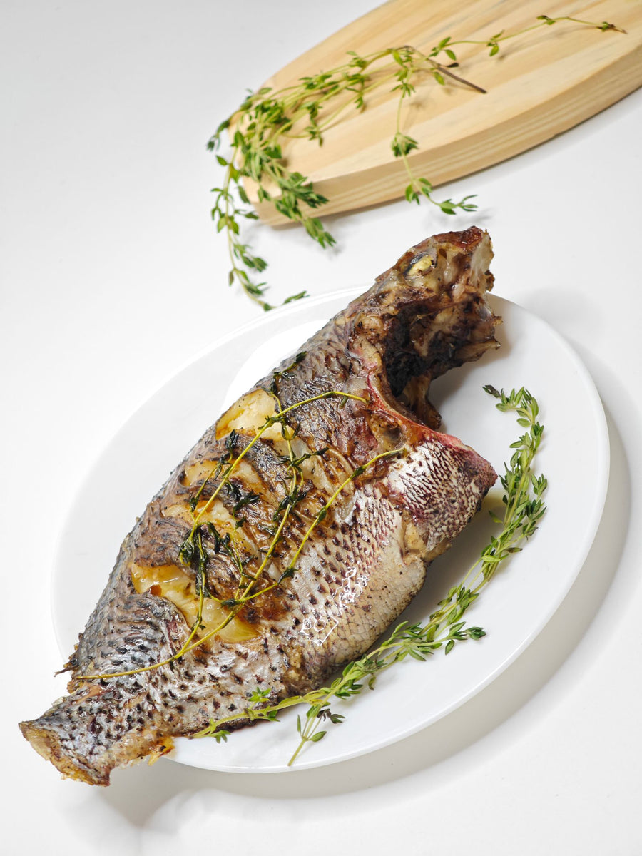 Whole fish with fresh herbs on a platter – photo by Masuma Rahaman, Pexels