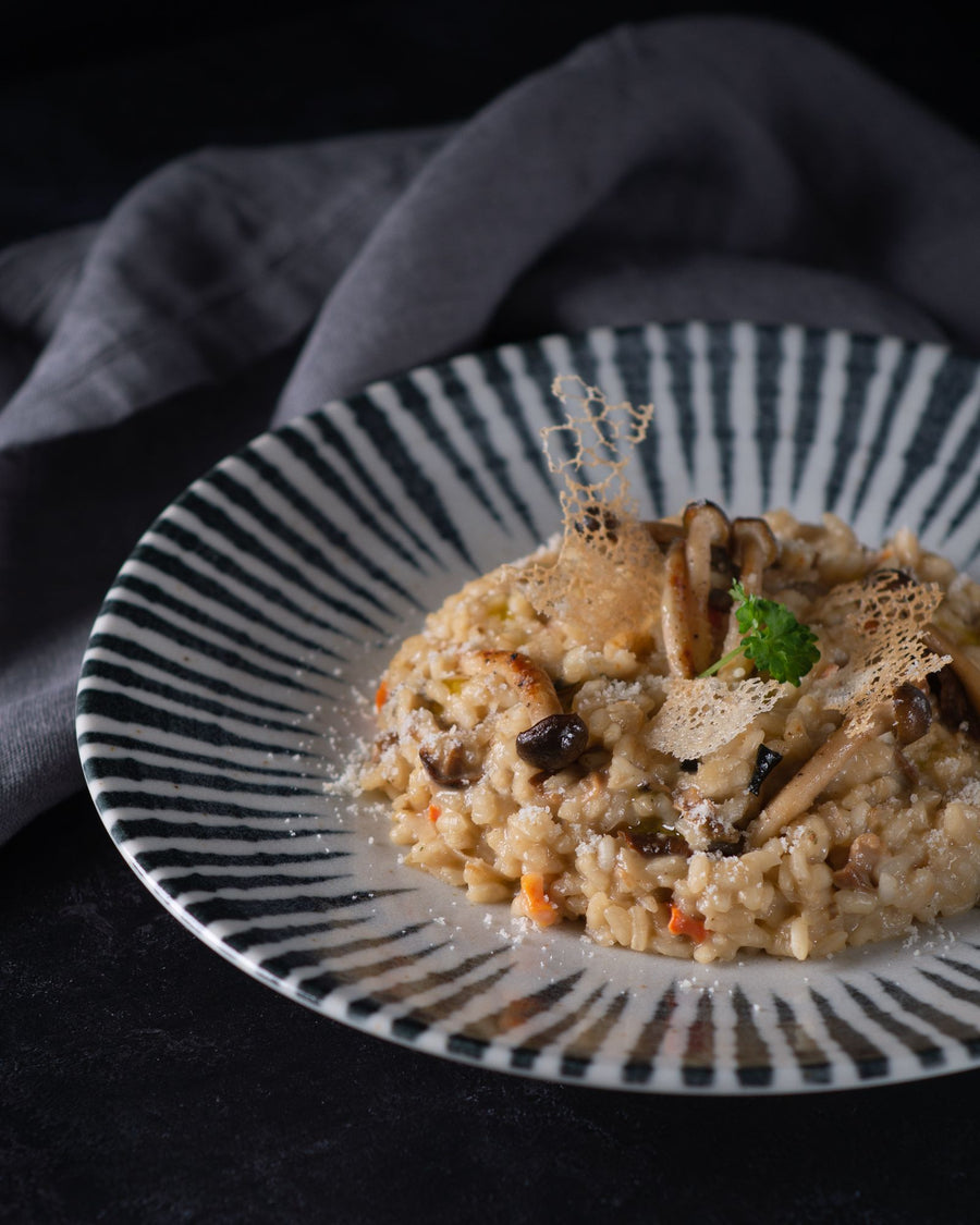 Mushroom risotto on a striped plate – photo by Max Griss, Pexels